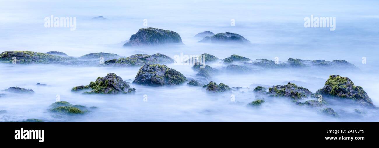 Longue exposition de l'océan mystère et des roches. Paysage tropical avec des pierres surréalistes sur la plage de la mer. Vue mystique étonnante de l'eau comme le brouillard et la brume. Magnifique Banque D'Images