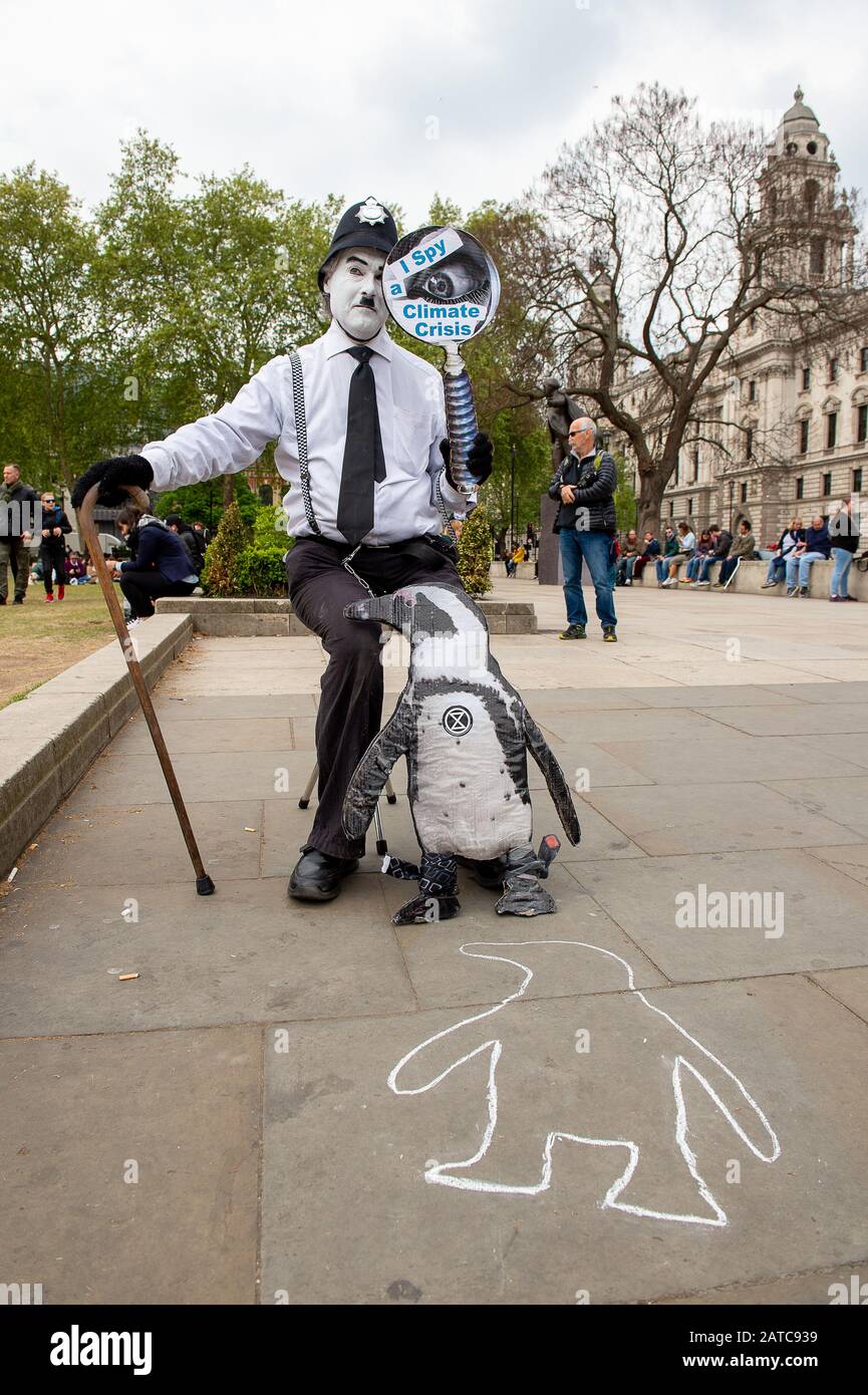 Westminster, Londres, Royaume-Uni. 1 mai 2019. Un homme hola un i Spy un signe de Crise climatique et repose un modèle de pingouin sur son genou. Crédit : Maureen Mclean/Alay Banque D'Images