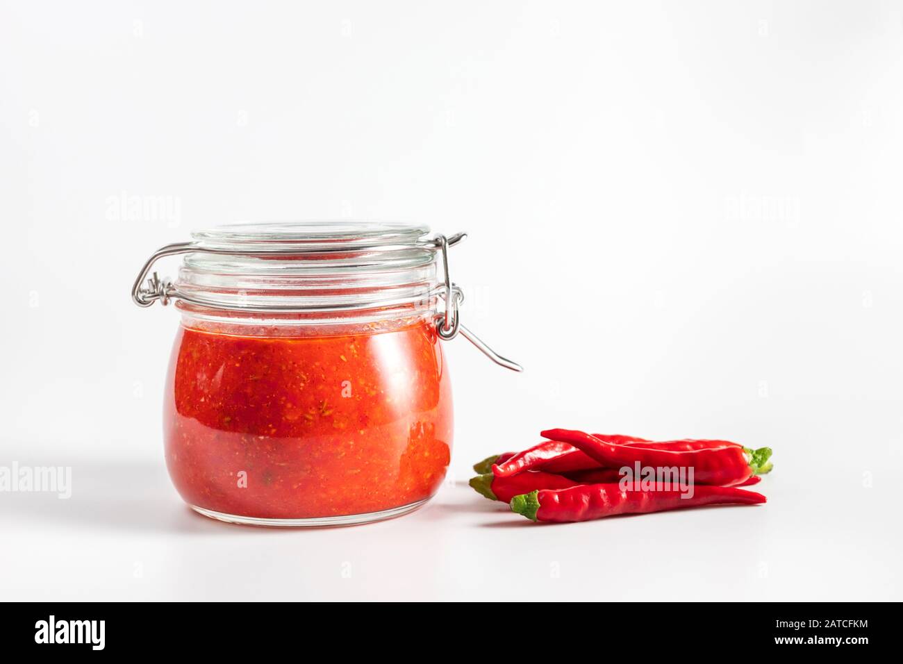 Sauce au piment chaud, pâte harissa. Adjika. Cuisine traditionnelle tunisienne, géorgienne et arabe. Harissa de rose maison dans un pot en verre. Banque D'Images
