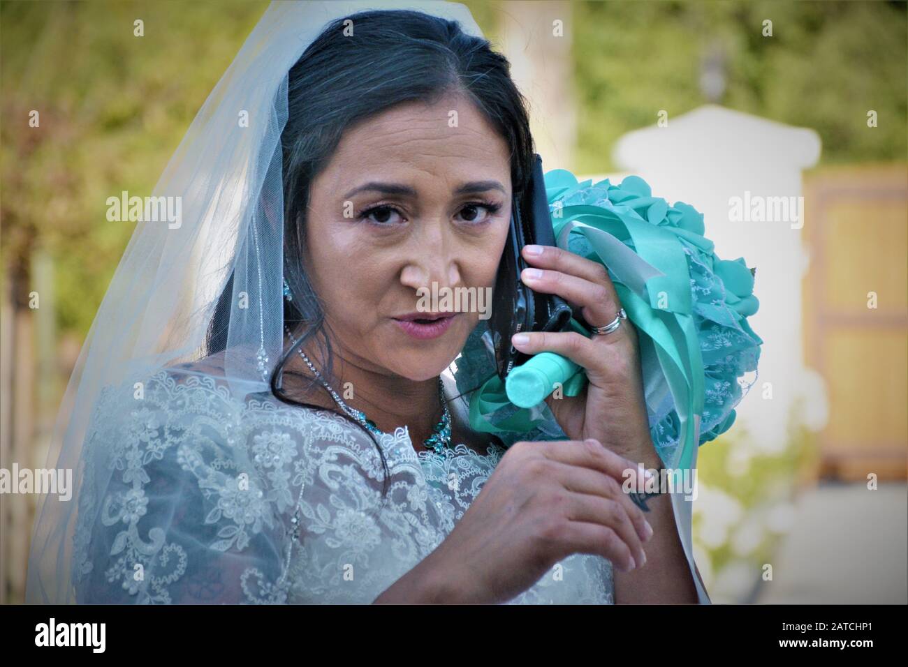 Femme à la mariée mariée parlant sur le téléphone cellulaire avec des personnes qui n'ont pas arrivé à la cueillette ethnique de cow-boy dans le sud de la Californie Banque D'Images