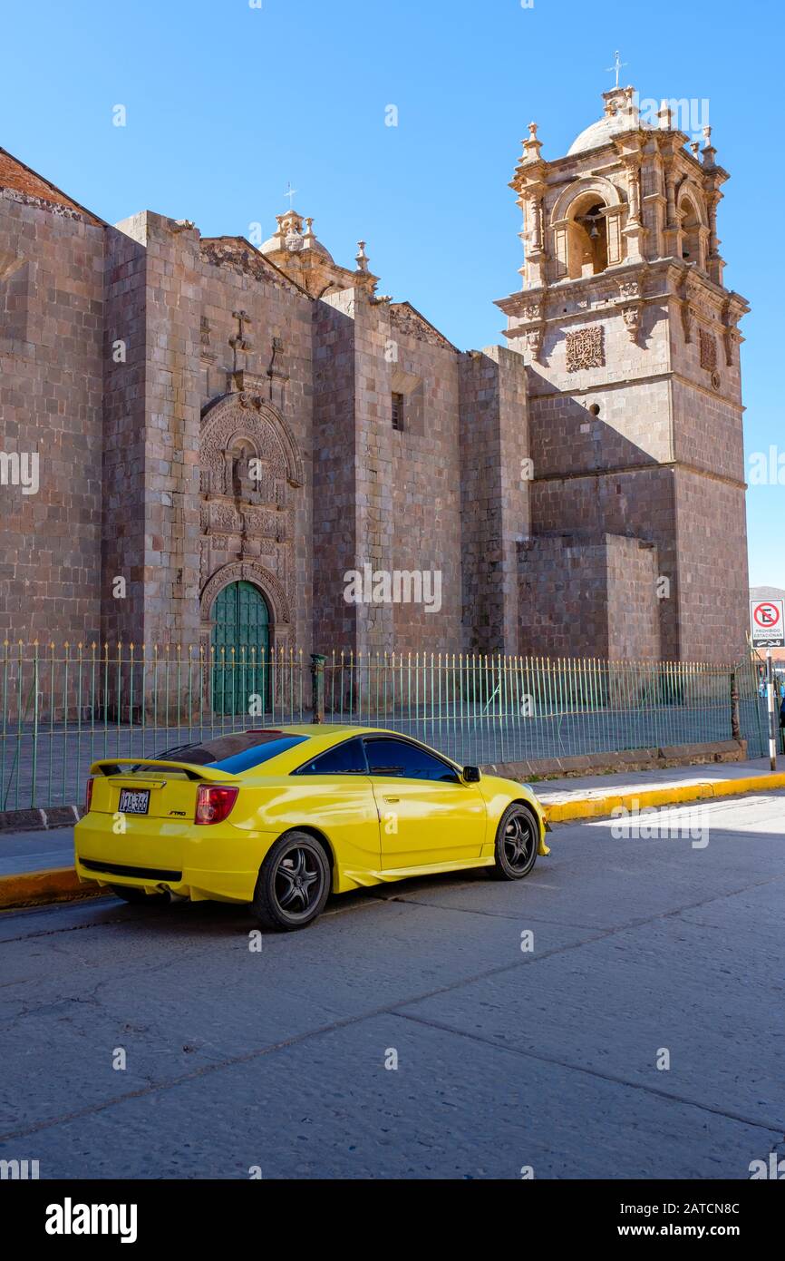 Toyota Celica TRD jaune stationné devant la basilique de la cathédrale Saint-Charles Borromeo, Puno, Pérou Banque D'Images