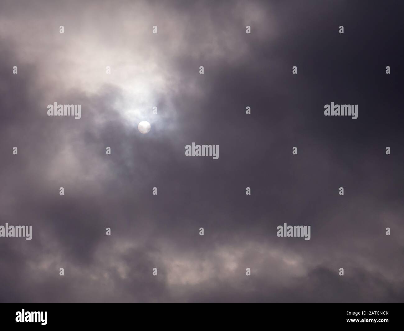 Le soleil traverse des nuages sombres. Banque D'Images