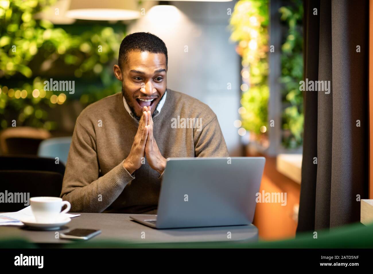 Homme d'affaires noir utilisant un ordinateur portable assis au café Banque D'Images