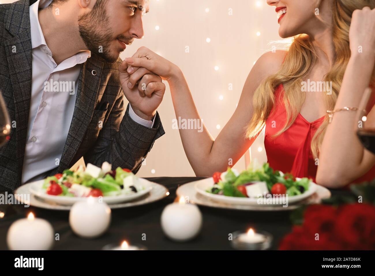 Gallant Man Kissing Main De Petite Amie Lors D'Un Dîner Romantique Au Restaurant Banque D'Images