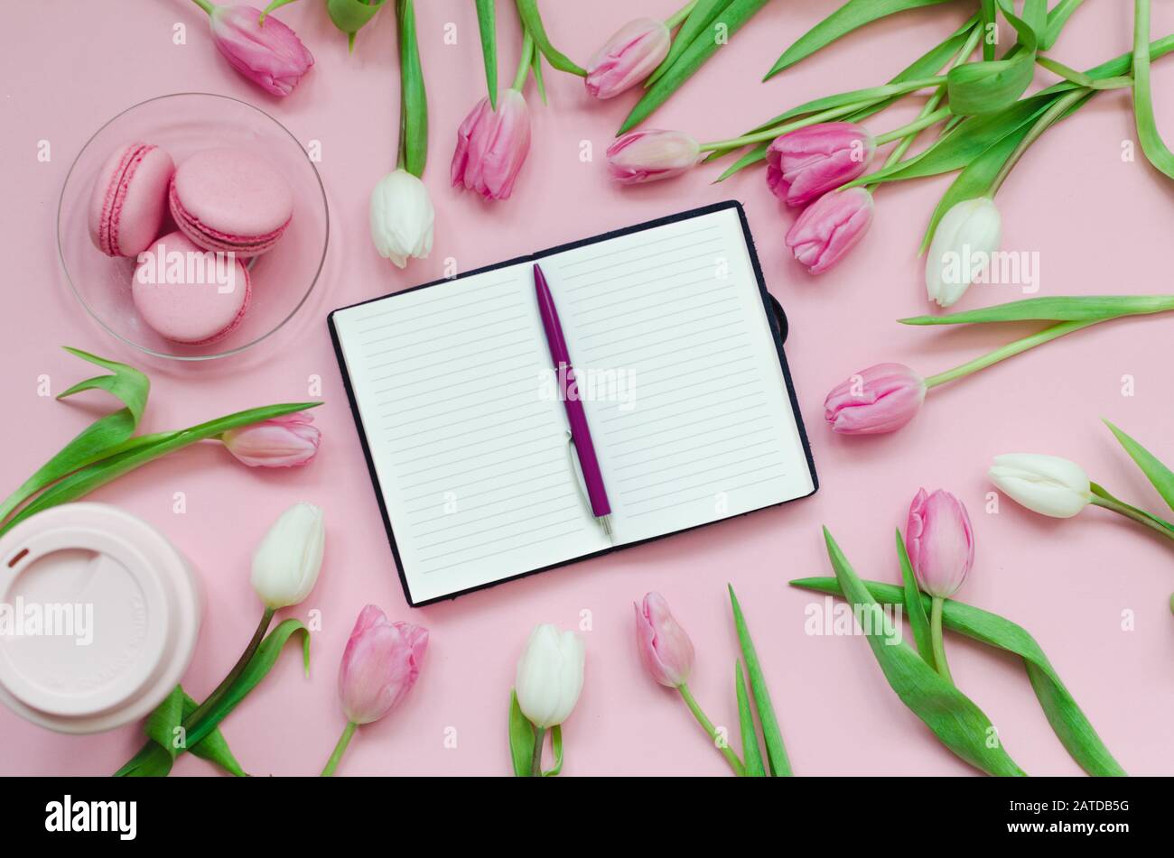 Bloc-notes avec liste de souhaits pour les plans futurs. Composition plat avec fleurs, bloc-notes, une tasse de café et des bonbons Banque D'Images