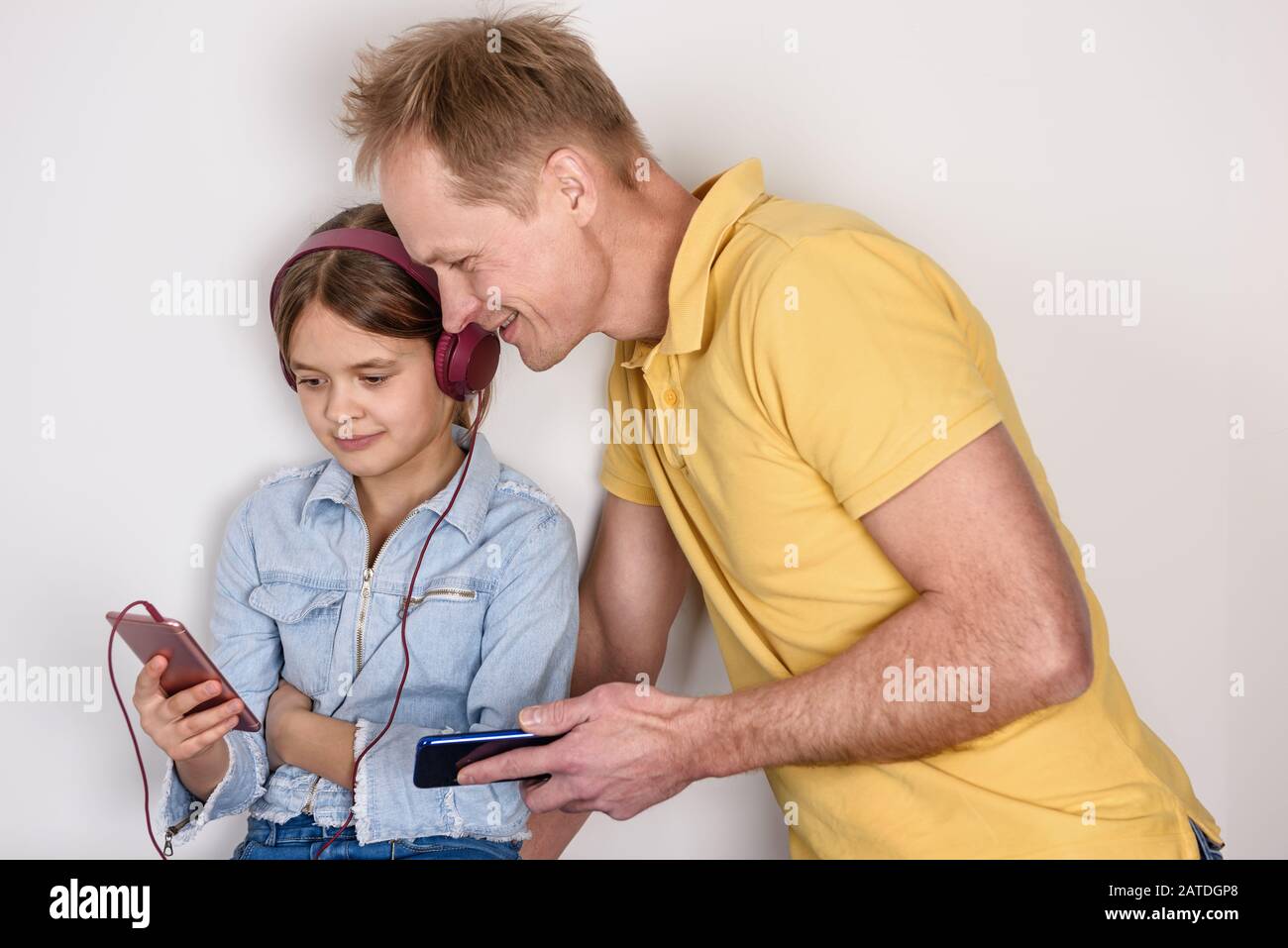Père et doughter regarder dans le smartphone et avoir un excellent temps. Un concept de famille heureux. Banque D'Images