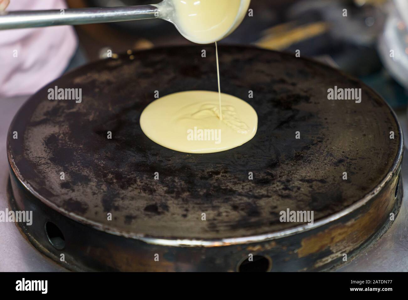 Verser la pâte à partir d'une louche de louches sur une pancake chaude  chaude. Le processus de fabrication de crêpes, la cuisine traditionnelle  thaïlandaise rapide pour les touristes Photo Stock - Alamy