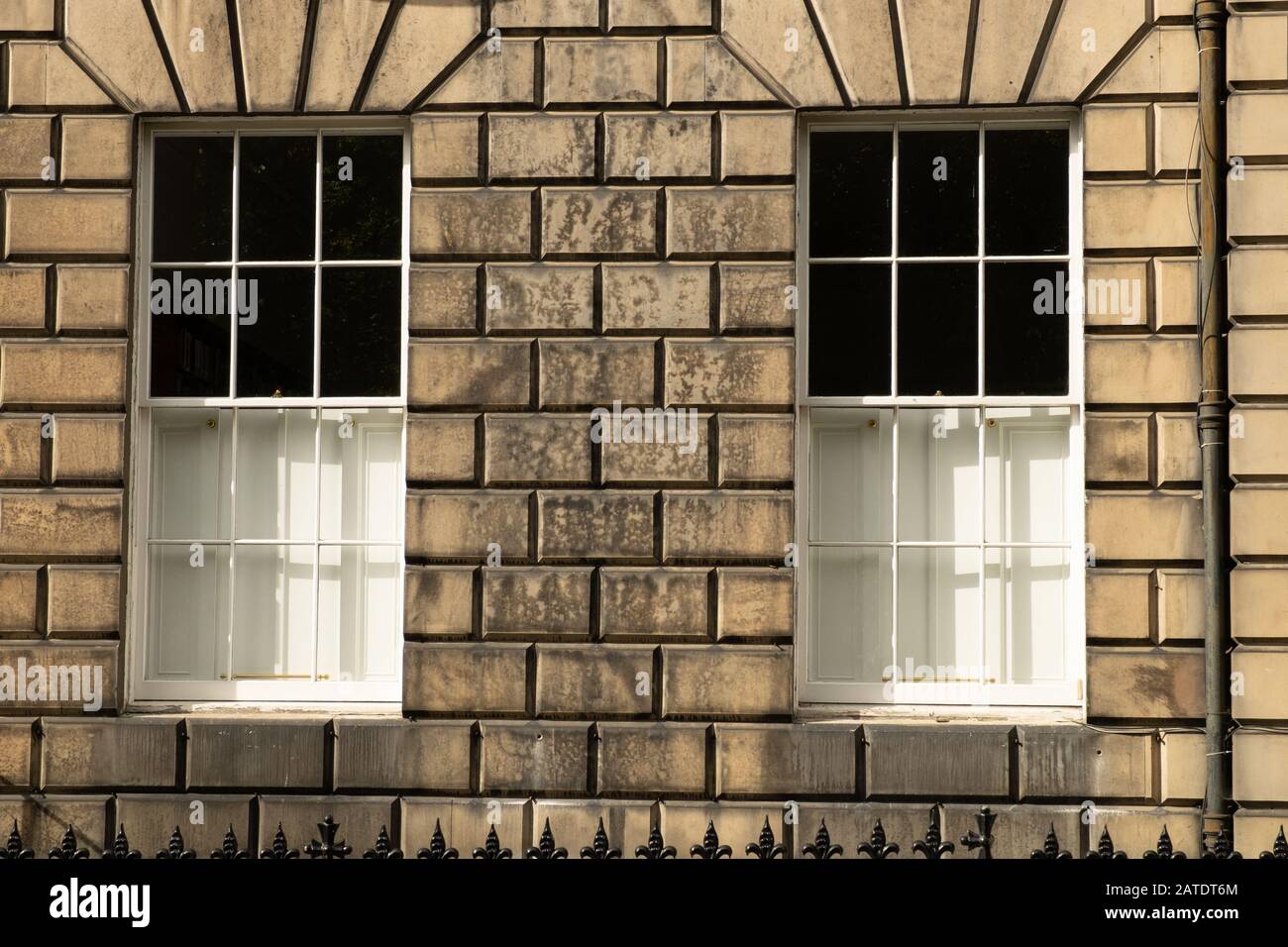 Deux fenêtres à cendres blanches traditionnelles identiques dans un mur de pierre de maison à Édimbourg, en Écosse Banque D'Images