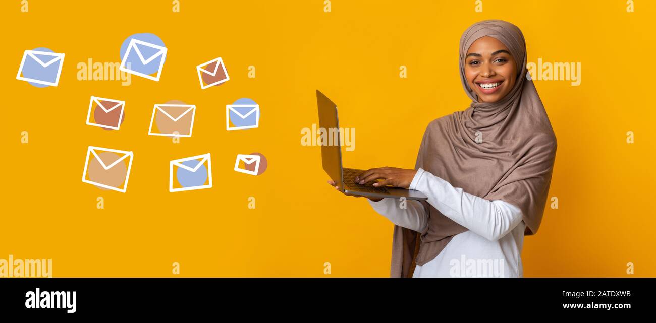 Happy Black Muslim Woman Avec Ordinateur Portable Et Enveloppes Volantes Sur Fond Banque D'Images
