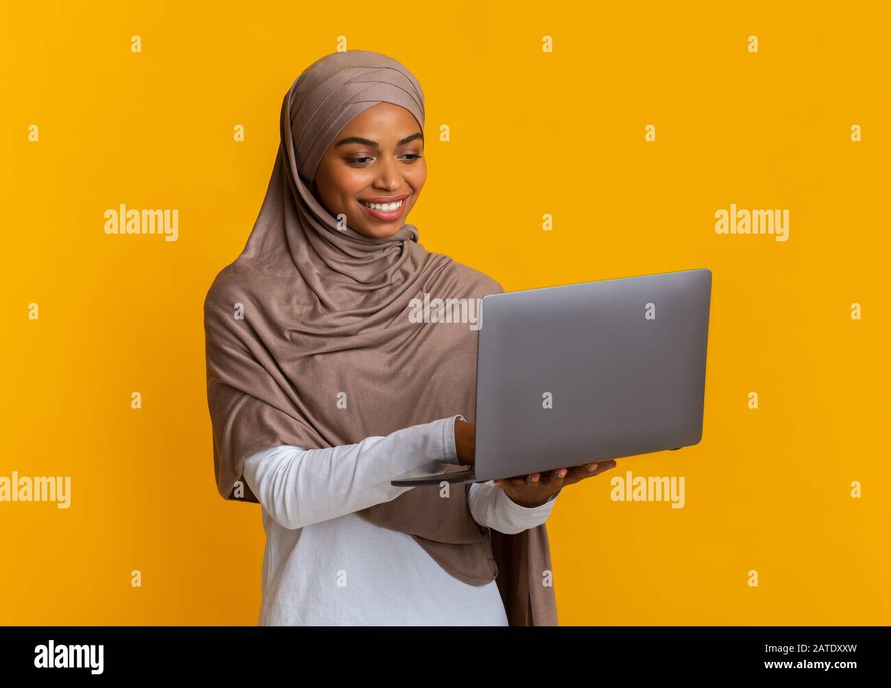 Afro Muslim Woman Travailleur Indépendant À Hijab Utilisant Ordinateur Portable, Travailler En Ligne Banque D'Images