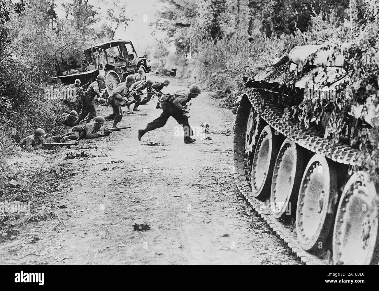 Les soldats américains traversent une route de terre, qui est sous feu ennemi, près de Saint-Lo, en Normandie, en France, le 25 juillet 1944. Banque D'Images