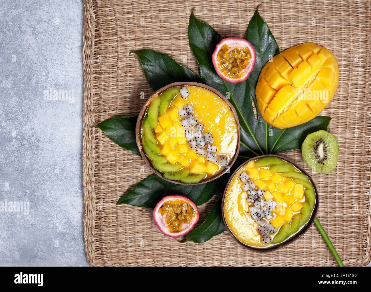bol à smoothie à la mangue avec kiwi, fruits du dragon et fruits de la passion sur fond gris en béton. vue du dessus Banque D'Images