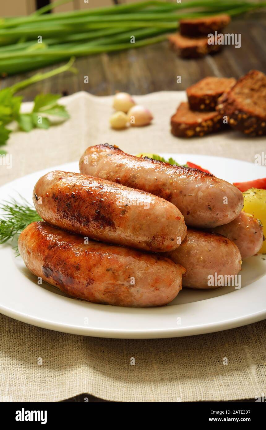 Saucisses appétissantes pour barbecue sur plaque blanche, vue rapprochée Banque D'Images