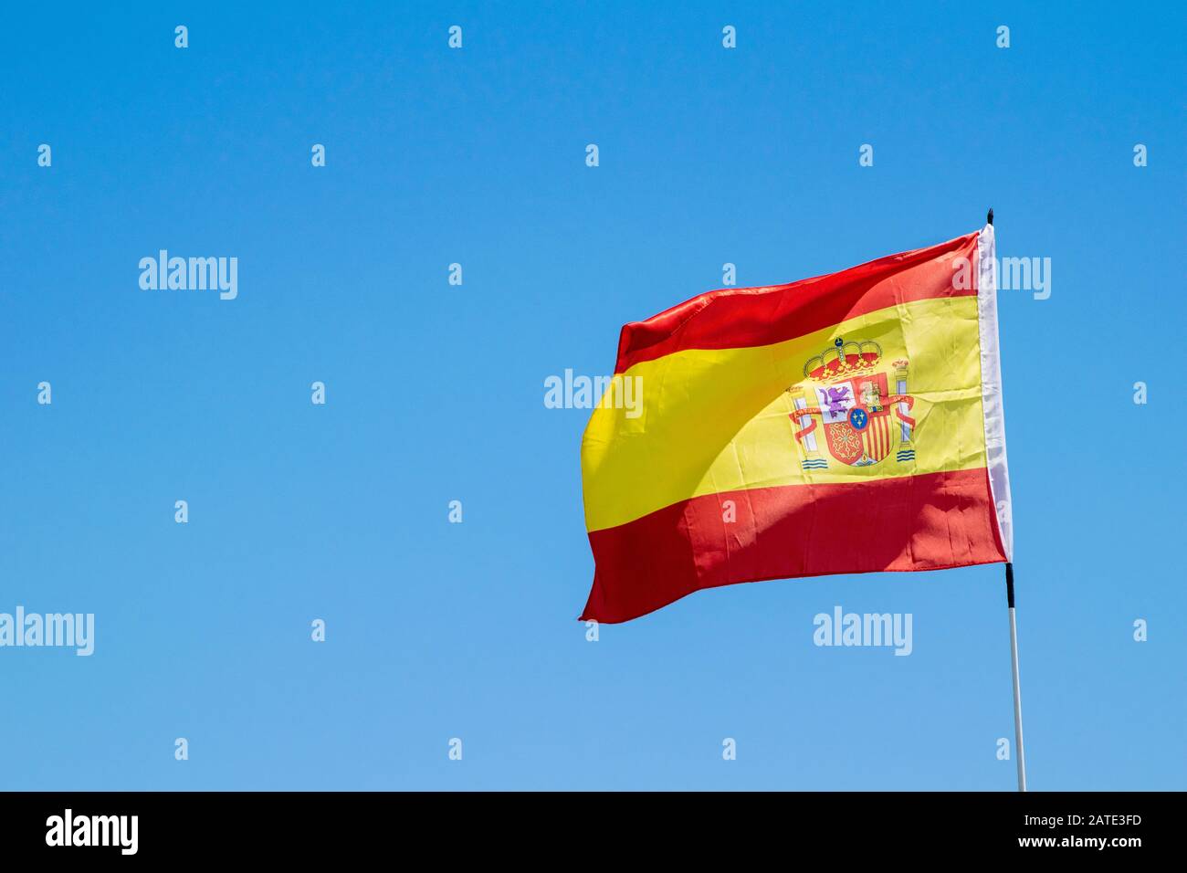 Un drapeau espagnol soufflant dans le vent avec un ciel bleu en arrière-plan à Marbella, Espagne Banque D'Images