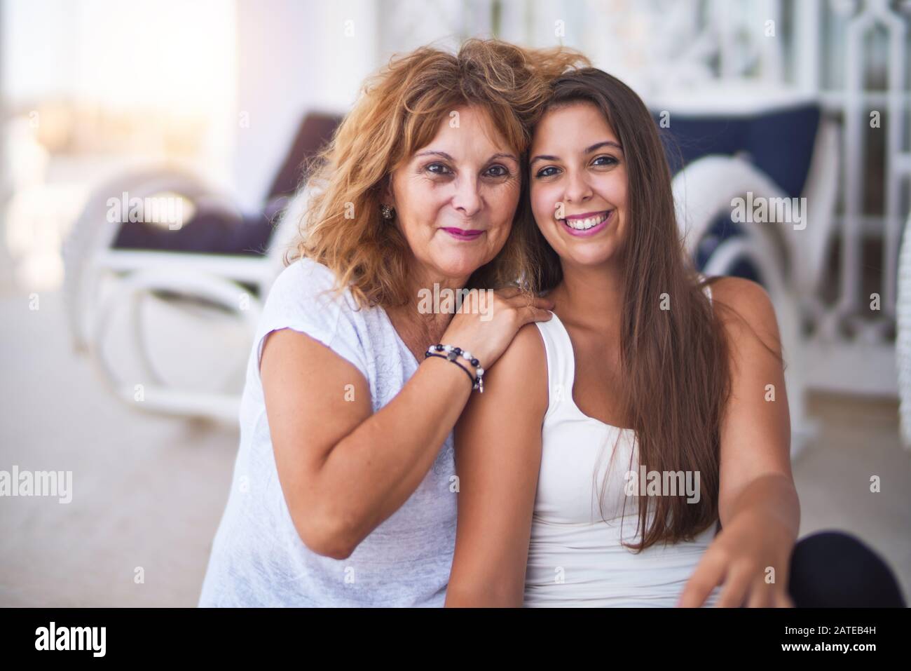 Belle Mère et fille assis à terrasse hugging and smiling Banque D'Images