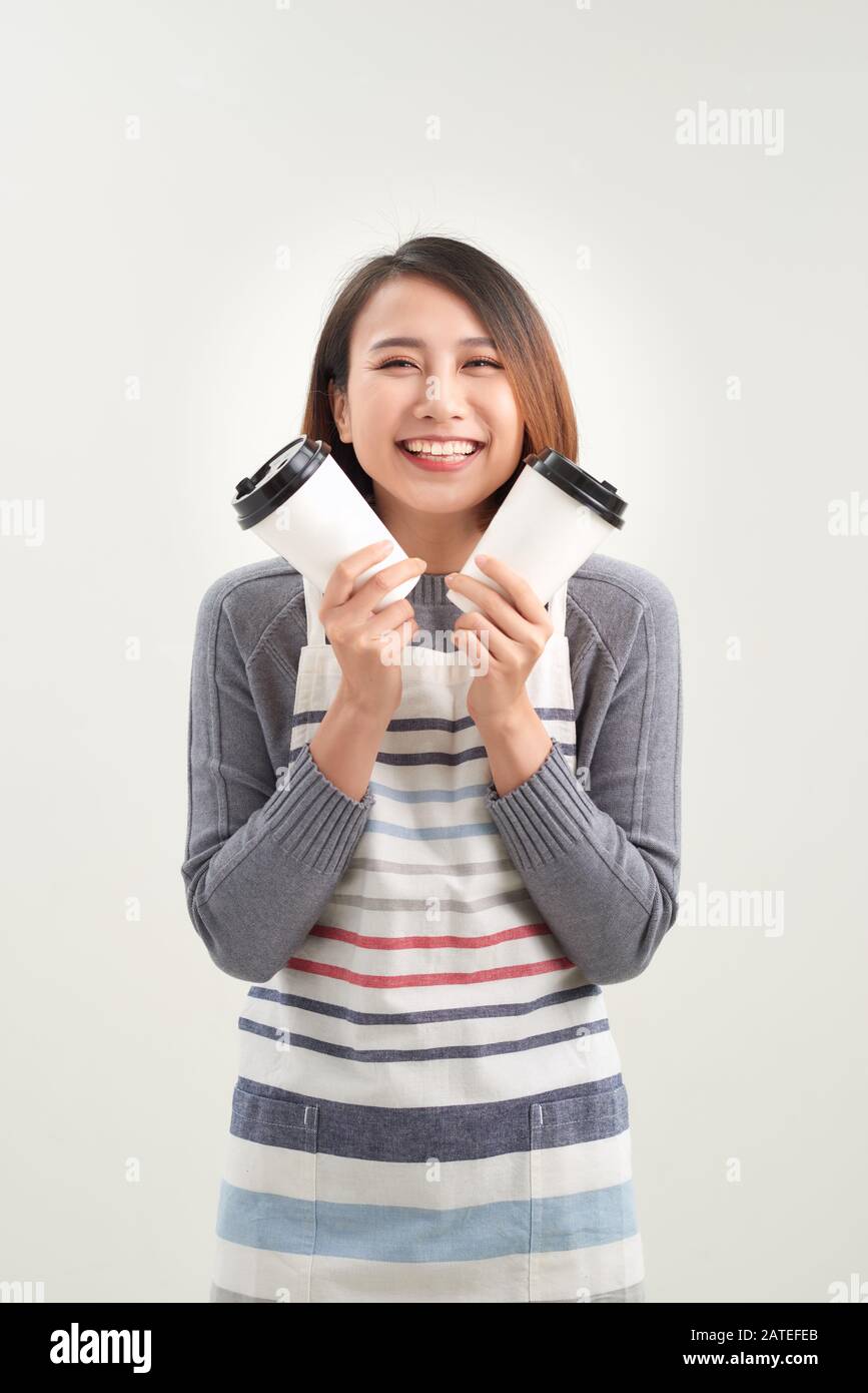 Gros plan photo magnifique sa femme serveuse propriétaire cafétéria tenir les mains bras en papier tasses boisson chaude inviter visite café porter tablier isolé W Banque D'Images