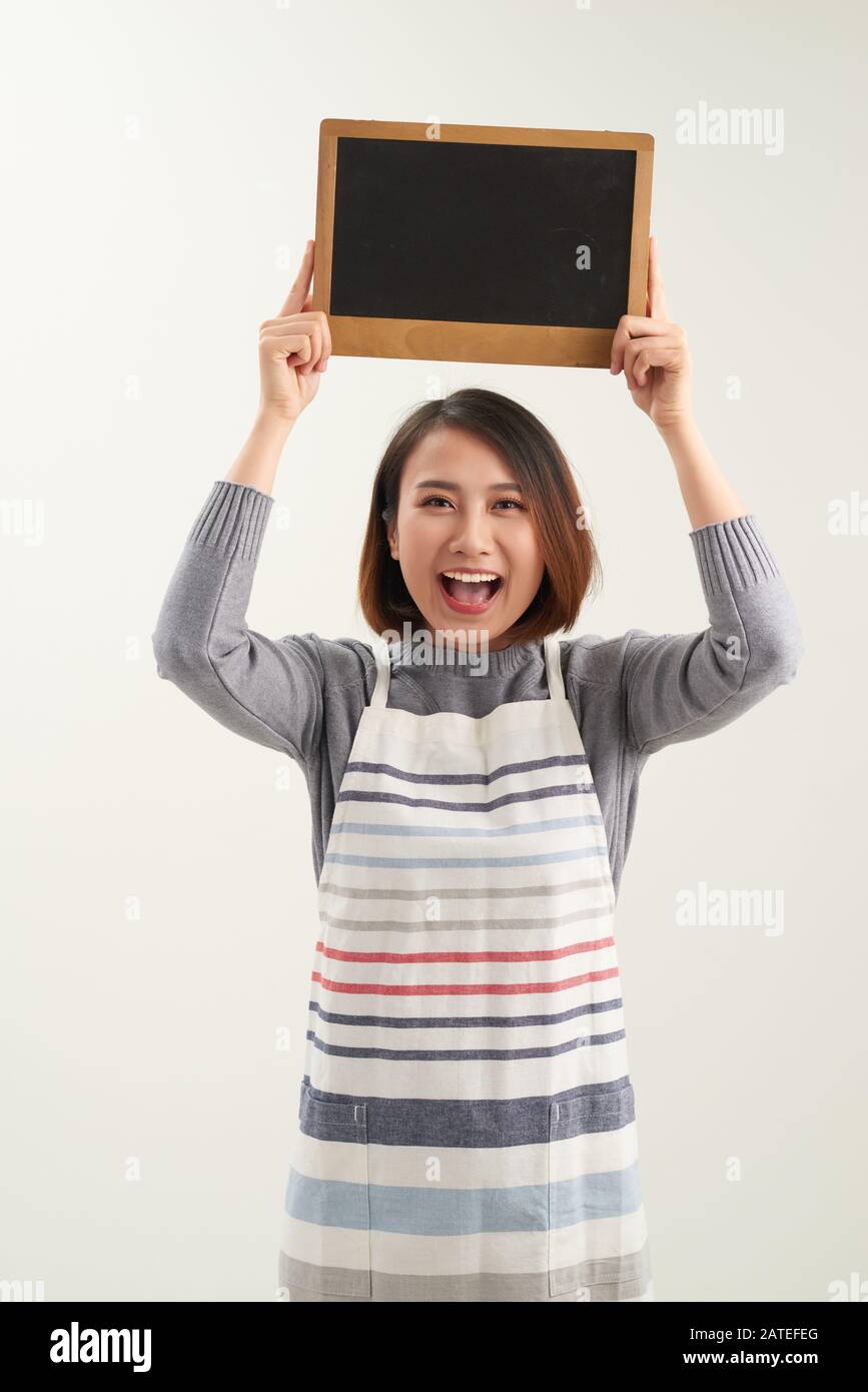 Jeune barista asiatique tenant un menu blanc de tableau de surveillance sur fond blanc Banque D'Images