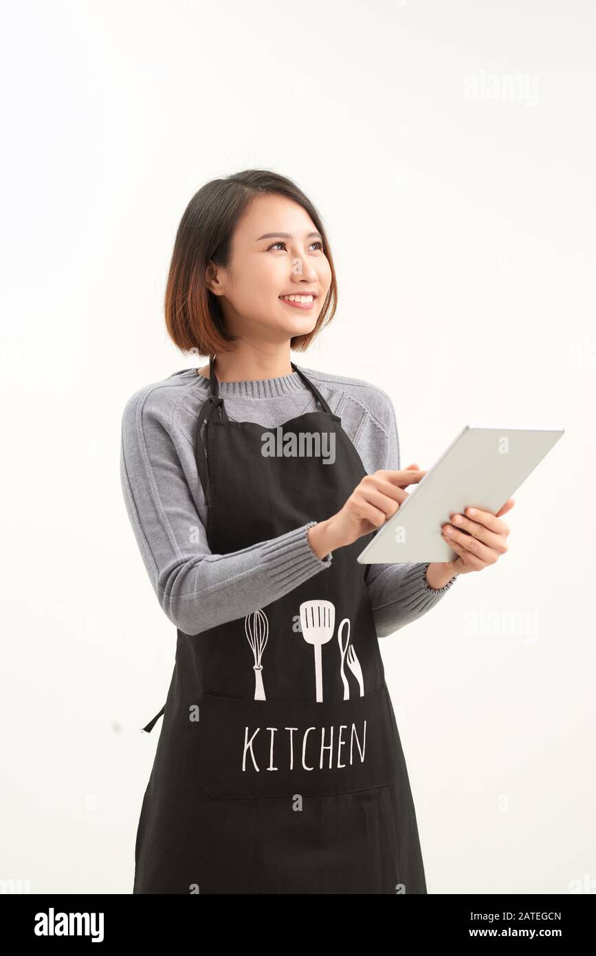 Heureux propriétaire de petite entreprise dans le tablier tenant la tablette debout sur fond blanc Banque D'Images