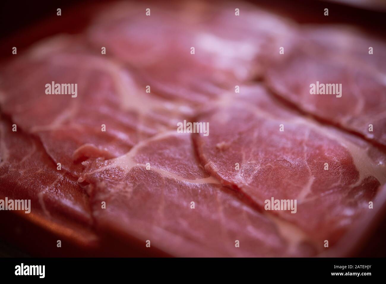 Tranches de viande de porc crues sur la plaque Banque D'Images