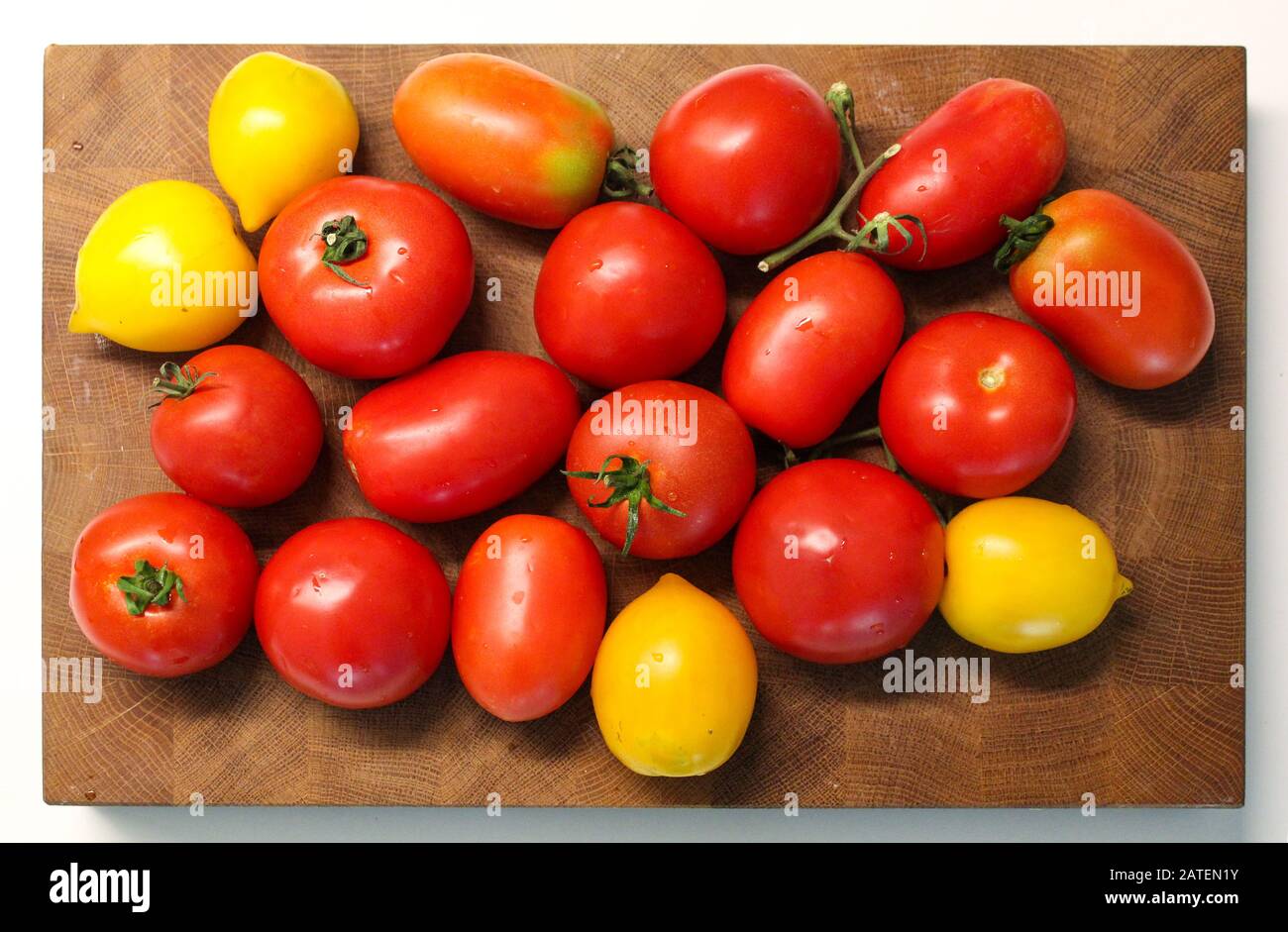 Tomates rouges et jaunes fraîches sur la planche à découper Banque D'Images