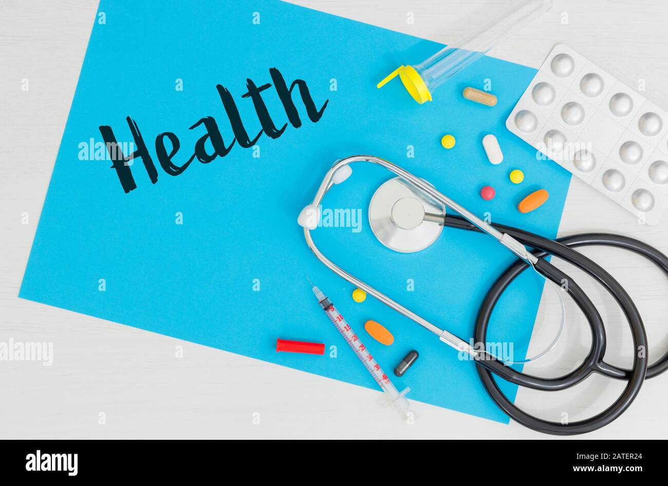 Médicament renversé qui avec un stéthoscope, un flacon de laboratoire, une seringue sur une carte bleue avec l'inscription 'Health' Place pour une inscription Banque D'Images
