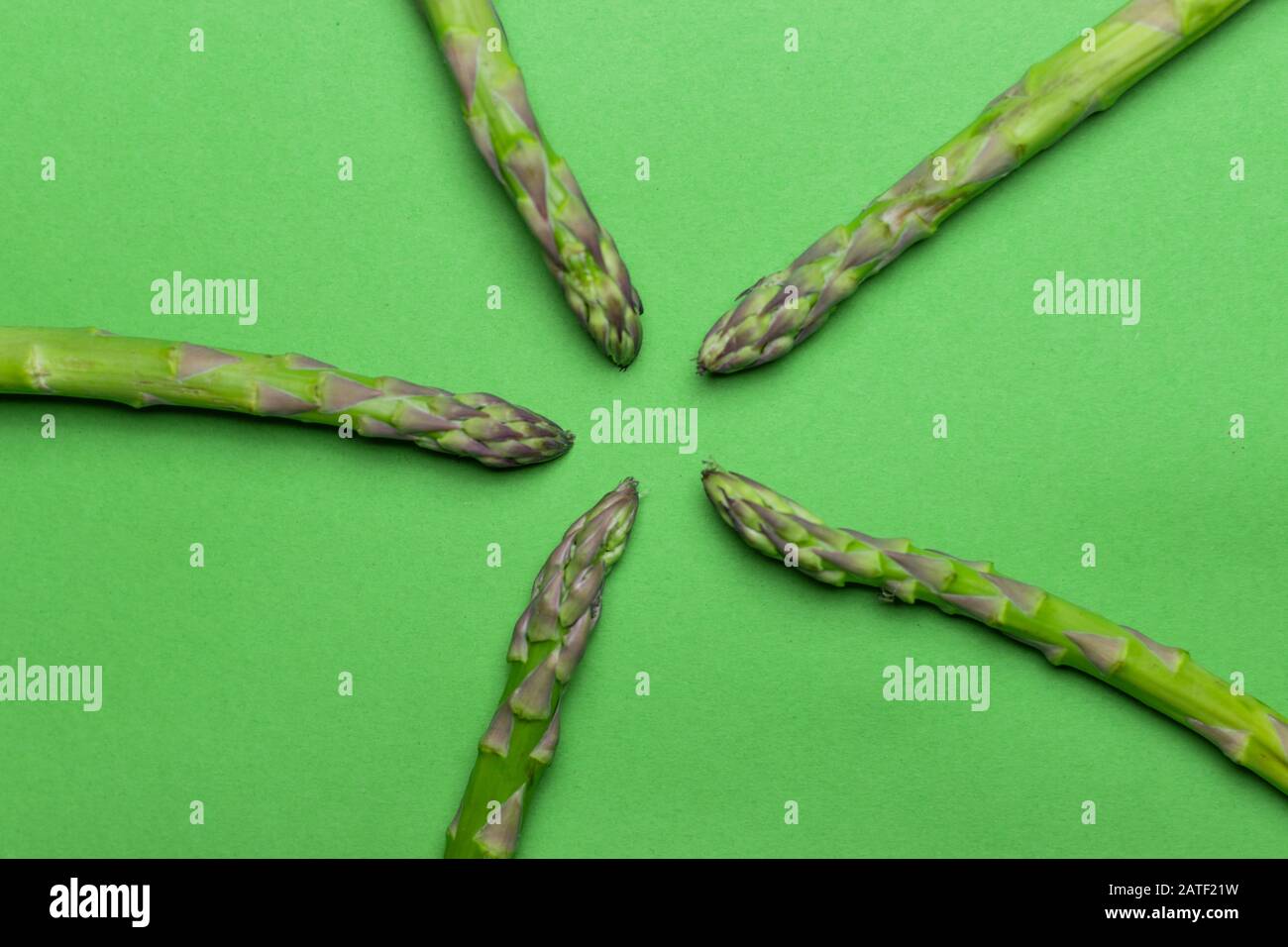 Asperges vertes brutes et saines sur fond vert. Detox et concept de super-alimentation. Banque D'Images