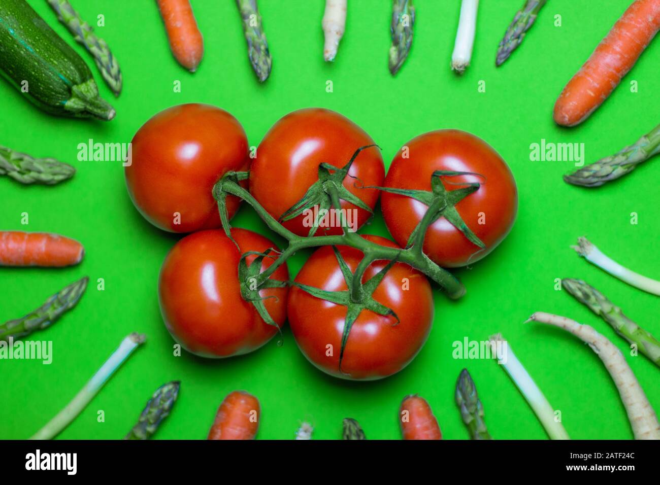 Légumes frais vert créatif fond. Concept alimentaire végétalien avec légumes biologiques crus. Tomatos, Carrot, Zucchini, parsnip, poireau et asperges on Banque D'Images