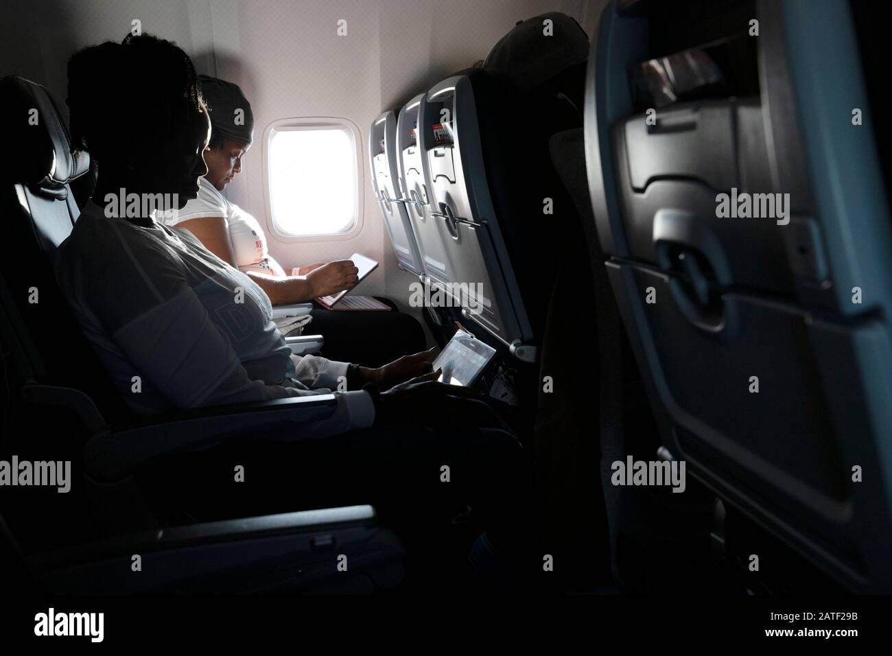 Passagers en avion à l'aide d'un appareil électronique Banque D'Images