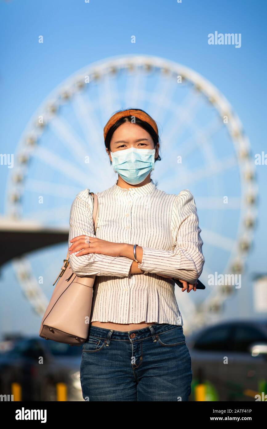 Fille asiatique portant un masque pour empêcher le virus à la gare routière Banque D'Images