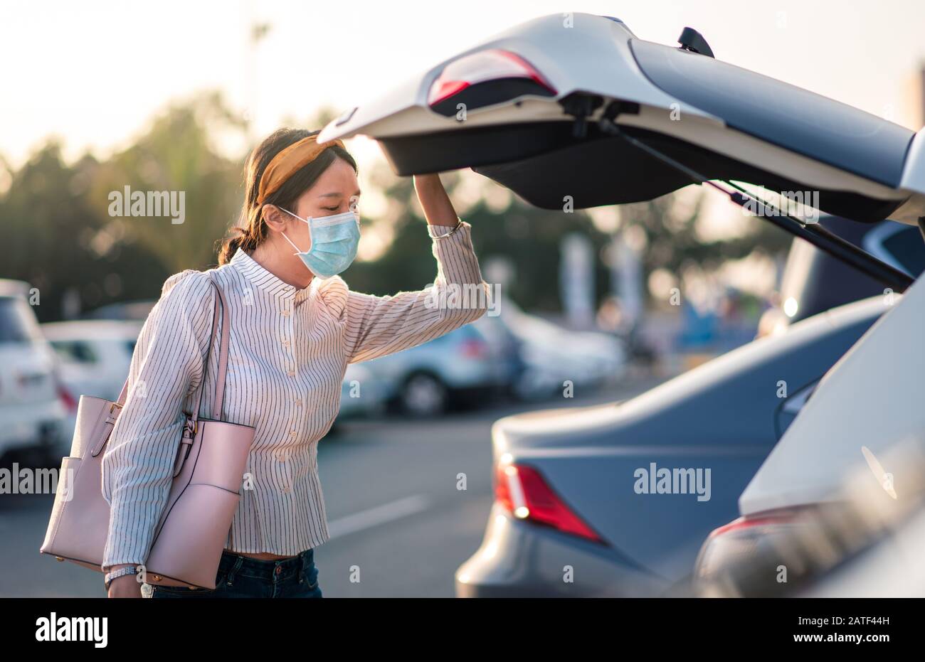Fille asiatique portant un masque de visage sur un parking extérieur Banque D'Images