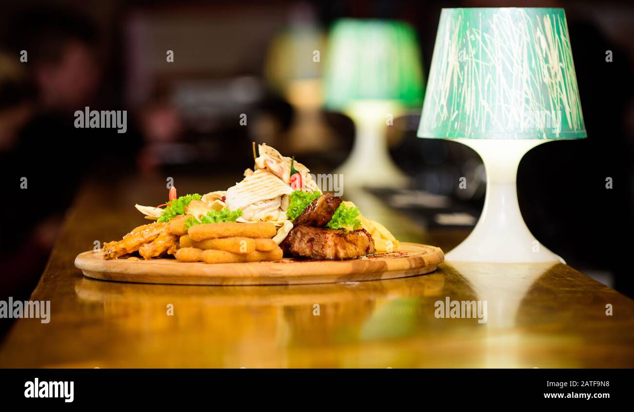Snack pour la bière. Planche de bois avec beaucoup de frites et bâtonnets de poisson viande burrito steak servi avec une salade. Menu snack-bar. Calories élevé pour le groupe d'amis. De délicieux en-cas savoureux. Les repas au restaurant. Banque D'Images