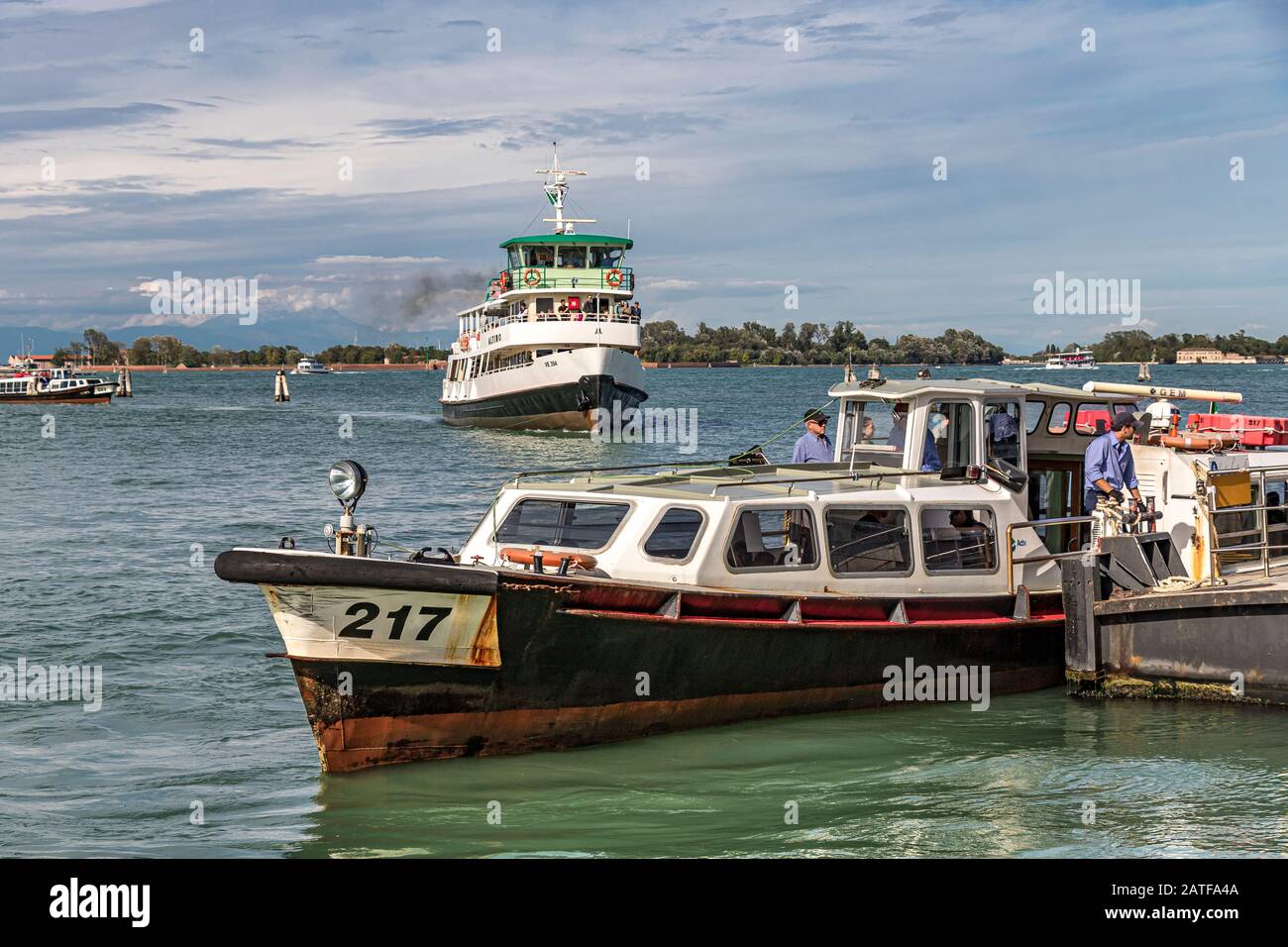 Un vaporetto ou un bateau-bus sur le Lido Vaporetto s'arrête lorsque le ferry Altino s'approche de la distance sur La lagune de Venise, Venise .Italie Banque D'Images