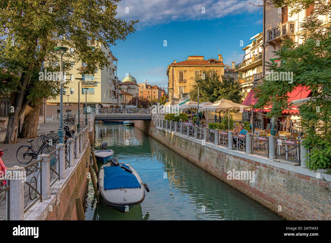 Les gens dans un restaurant le long du canal sur Via Vettor Pisani, Lido, Venise, Italie Banque D'Images