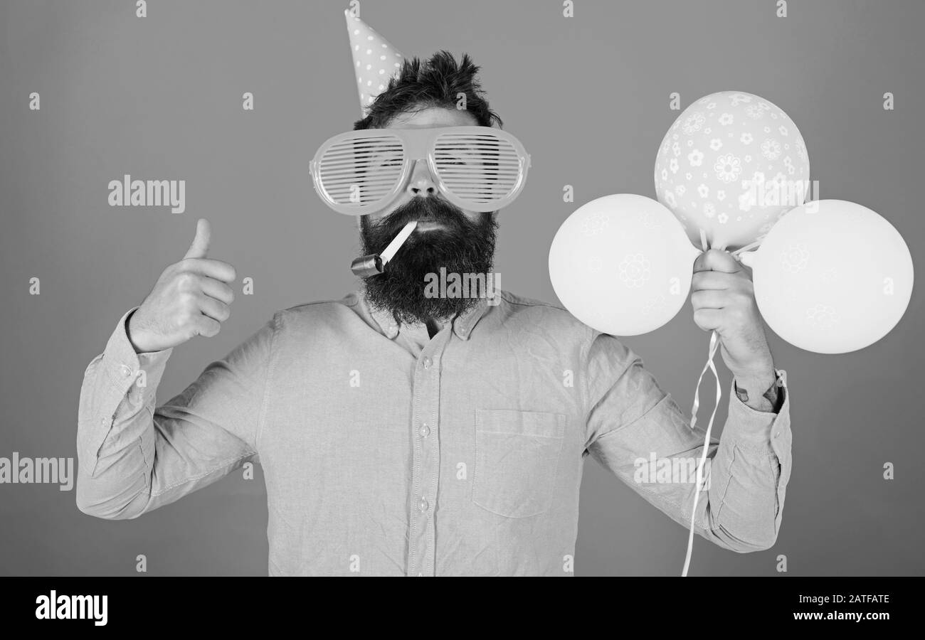 Fete D Anniversaire Surprise Avec Decoration De Ballons Homme Barbu Dans Une Chemise Rose Montrant Le Pouce Vers Le Haut Hipster Avec Des Verres Enormes Et Un Sifflet De Fete Isole Sur Fond
