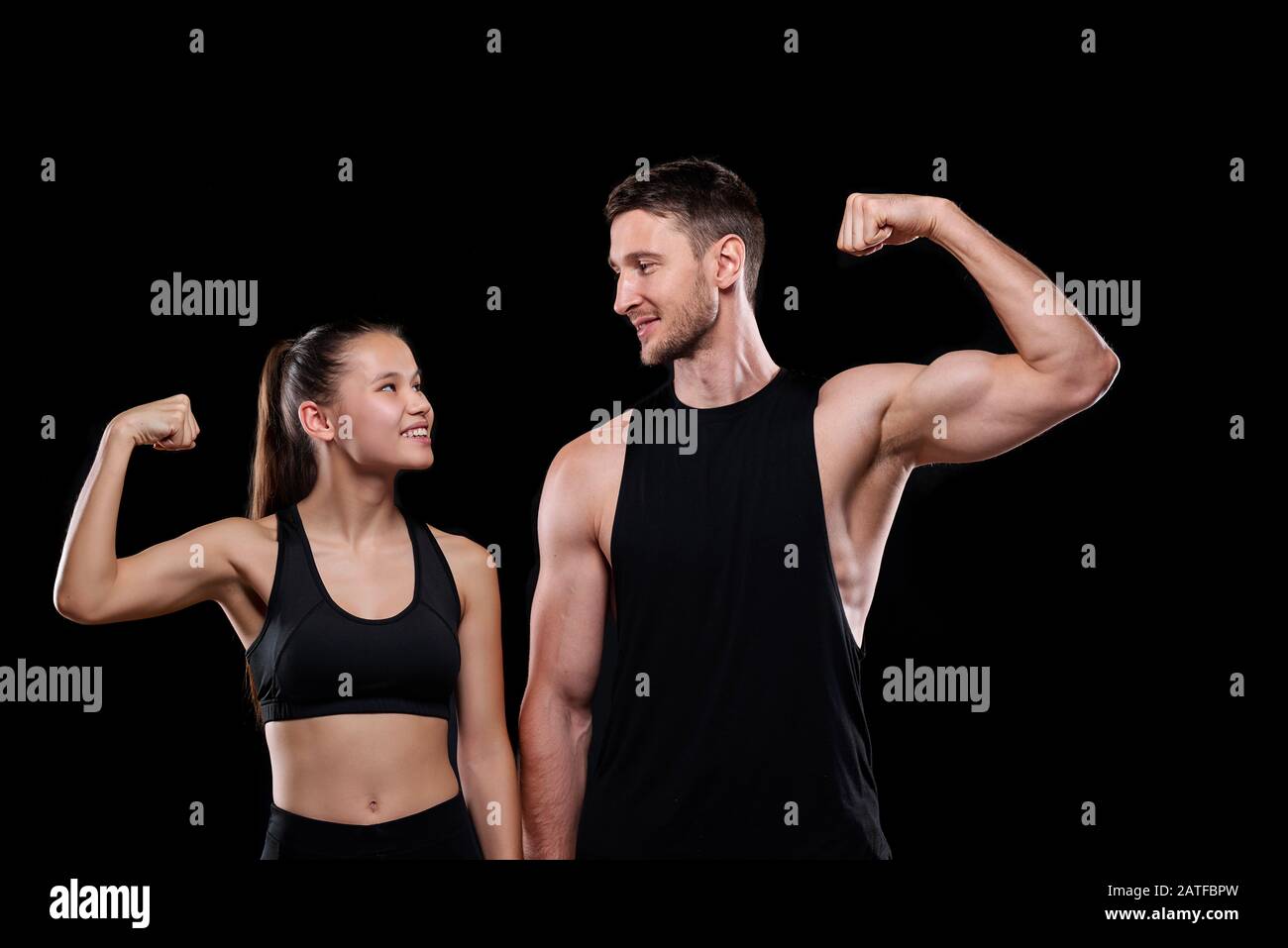 Jeune couple de sports joyeux dans l'activewear se regardant les uns les autres Banque D'Images