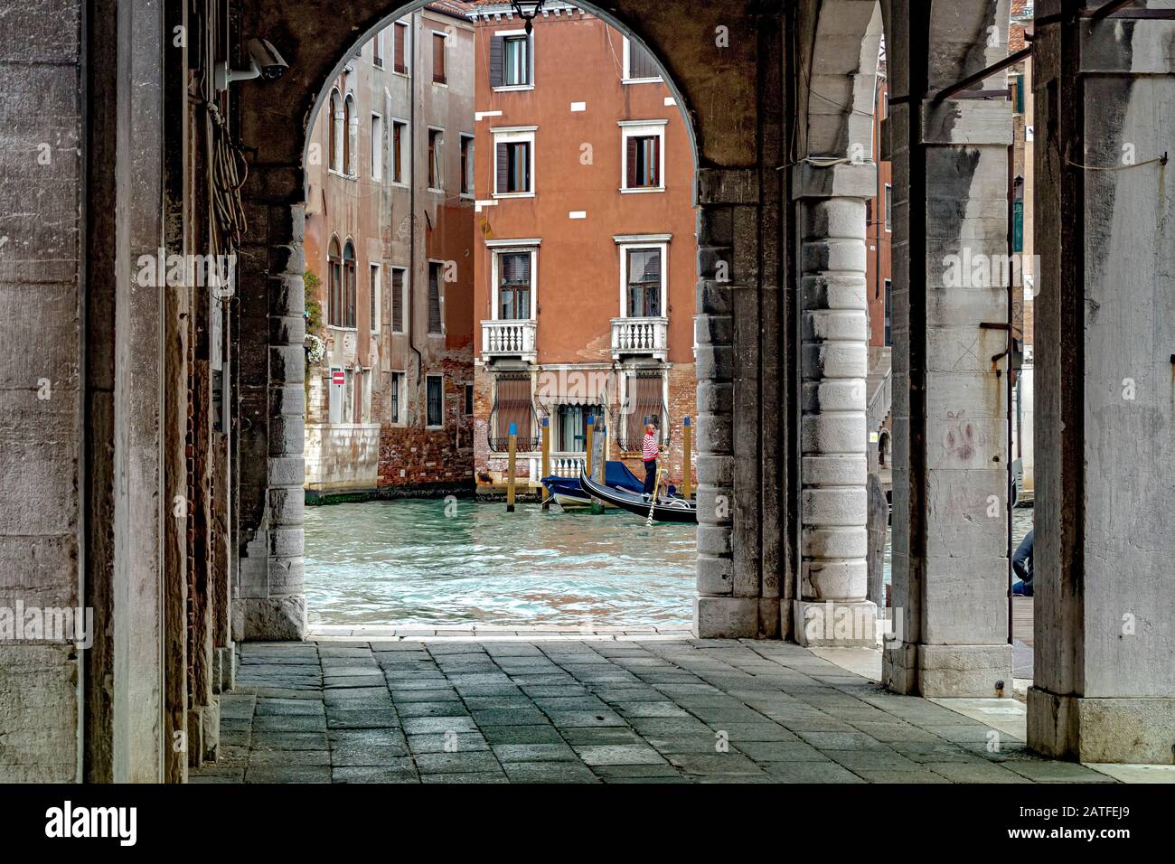 En regardant par un arc en pierre au marché du Rialto comme une télécabine passe par le Grand Canal Venise, Italie Banque D'Images