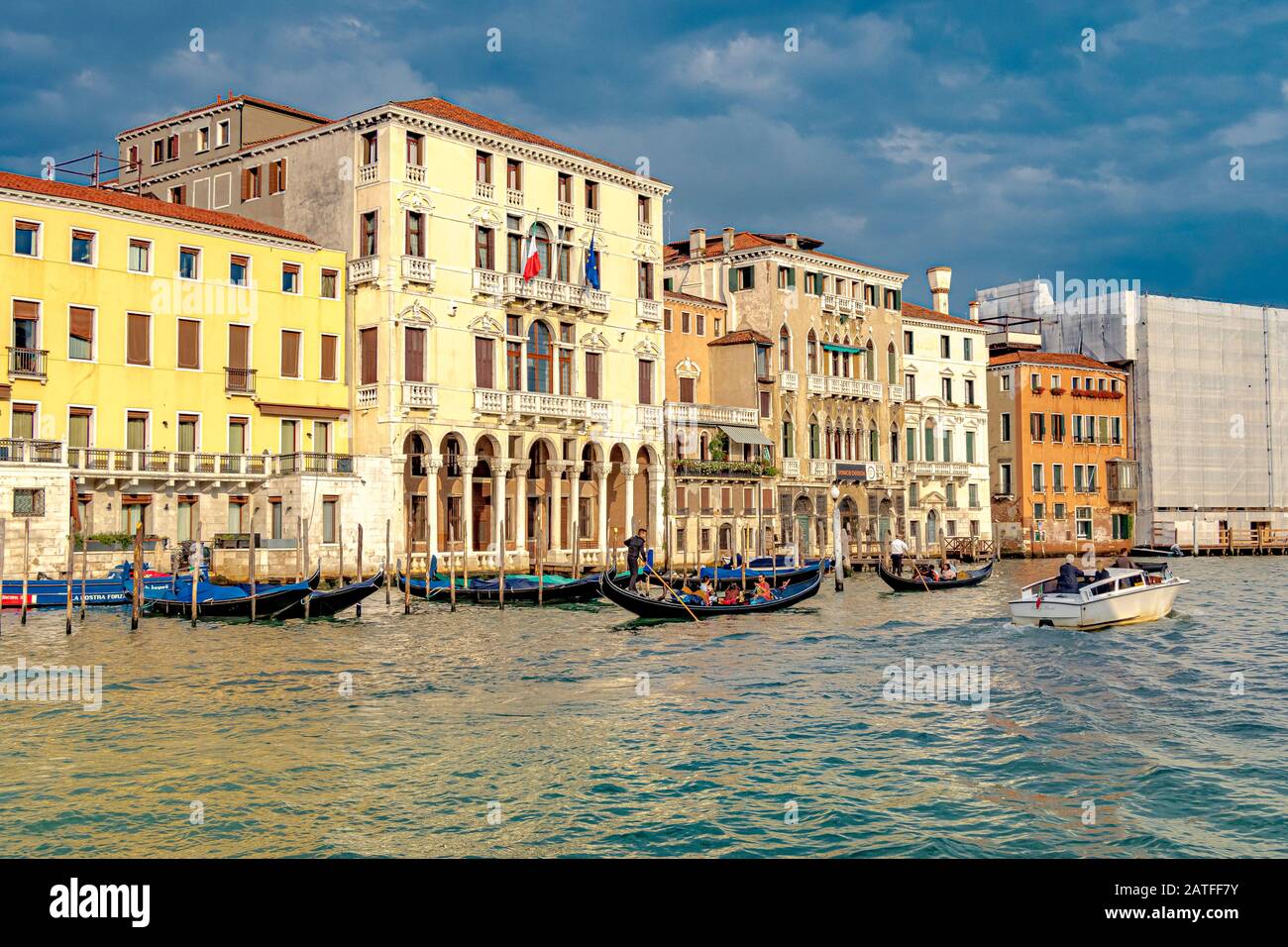 Les gondoles et un bateau-taxi sur Le grand Canal, car la lumière du soleil de la fin de l'après-midi reflète les bâtiments baroques le long du Grand Canal à Venise, en Italie Banque D'Images