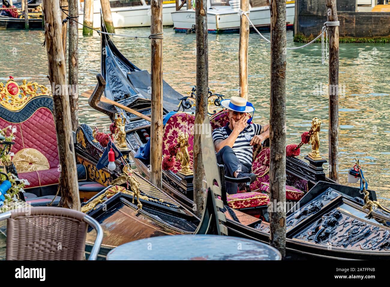 Un Gondolier prenant un repos, assis dans sa télécabine sur le Grand Canal, Venise, Italie Banque D'Images