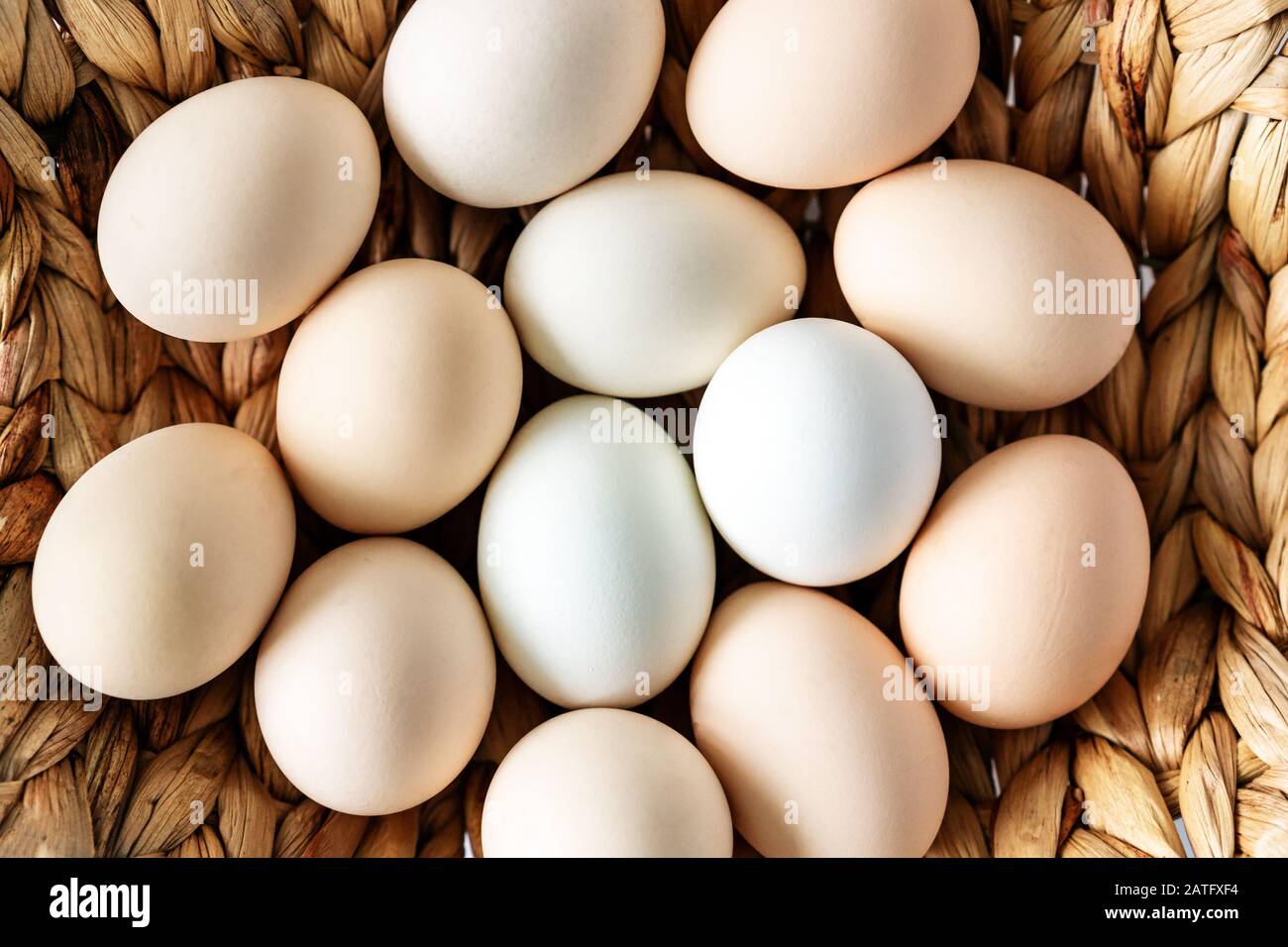 Des œufs frais de chiken biologiques de ferme dans un panier sur fond de blanita. Alimentation saine naturelle et agriculture biologique, concept de pâques. Banque D'Images