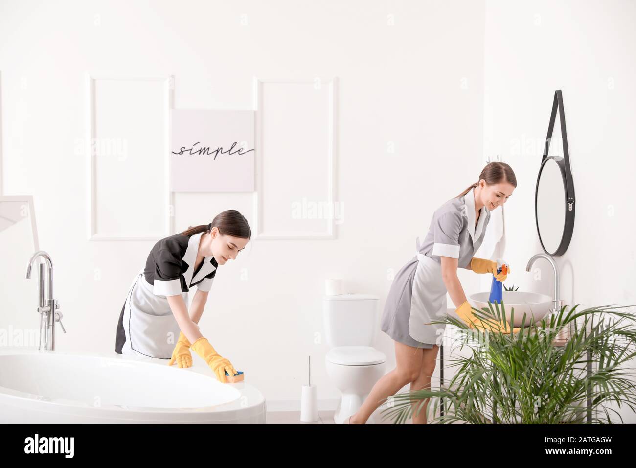Belle chambre chambermaids nettoyage de la salle de bains de l'hôtel Banque D'Images