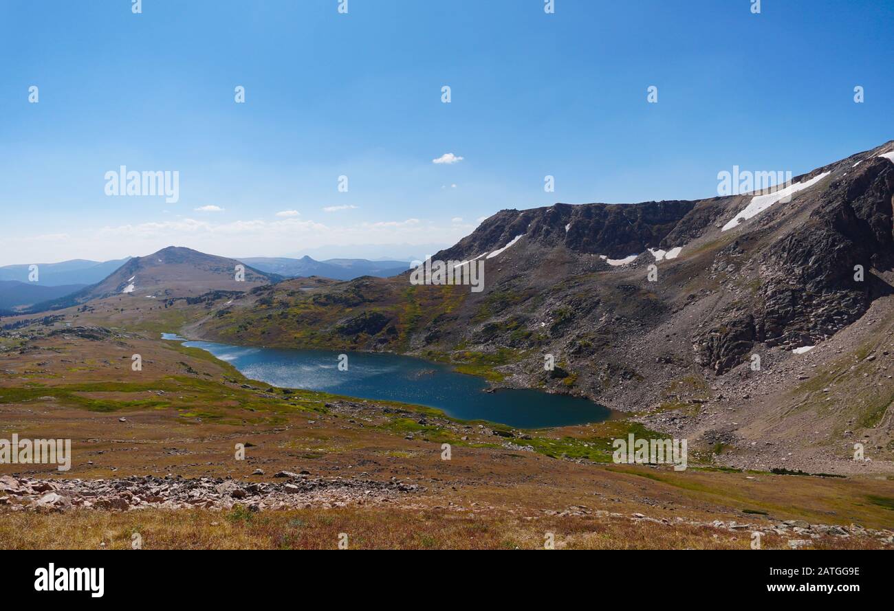 En regardant vers le bas sur un lac étincelant de haute altitude et les montagnes au-delà de la Beartooth Highway. Banque D'Images