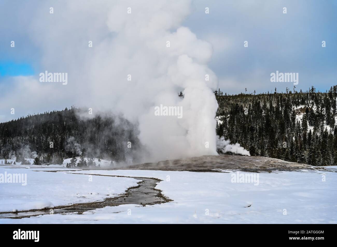 Le vieux geyser Fidèle éclate dans une journée d'hiver, à la vapeur d'ébouchage et à l'eau chaude dans le ciel. Yellowstone National Park, Wyoming, États-Unis. Banque D'Images