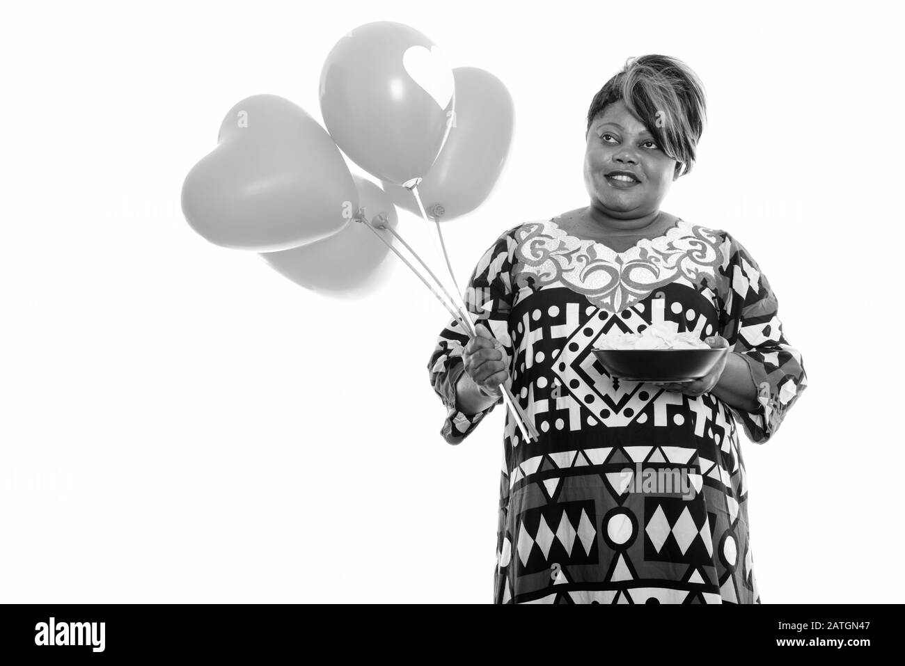 Heureuse femme africaine en surpoids tenant bol de chips de pommes de terre et de botte de ballons Banque D'Images