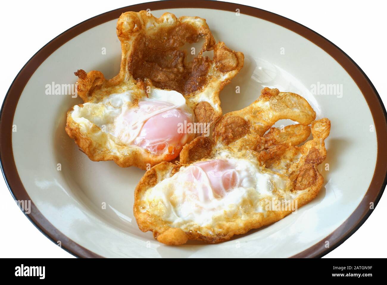 En gros plan, des œufs frits croustillants de style thaïlandais sont cuits dans une assiette. Banque D'Images