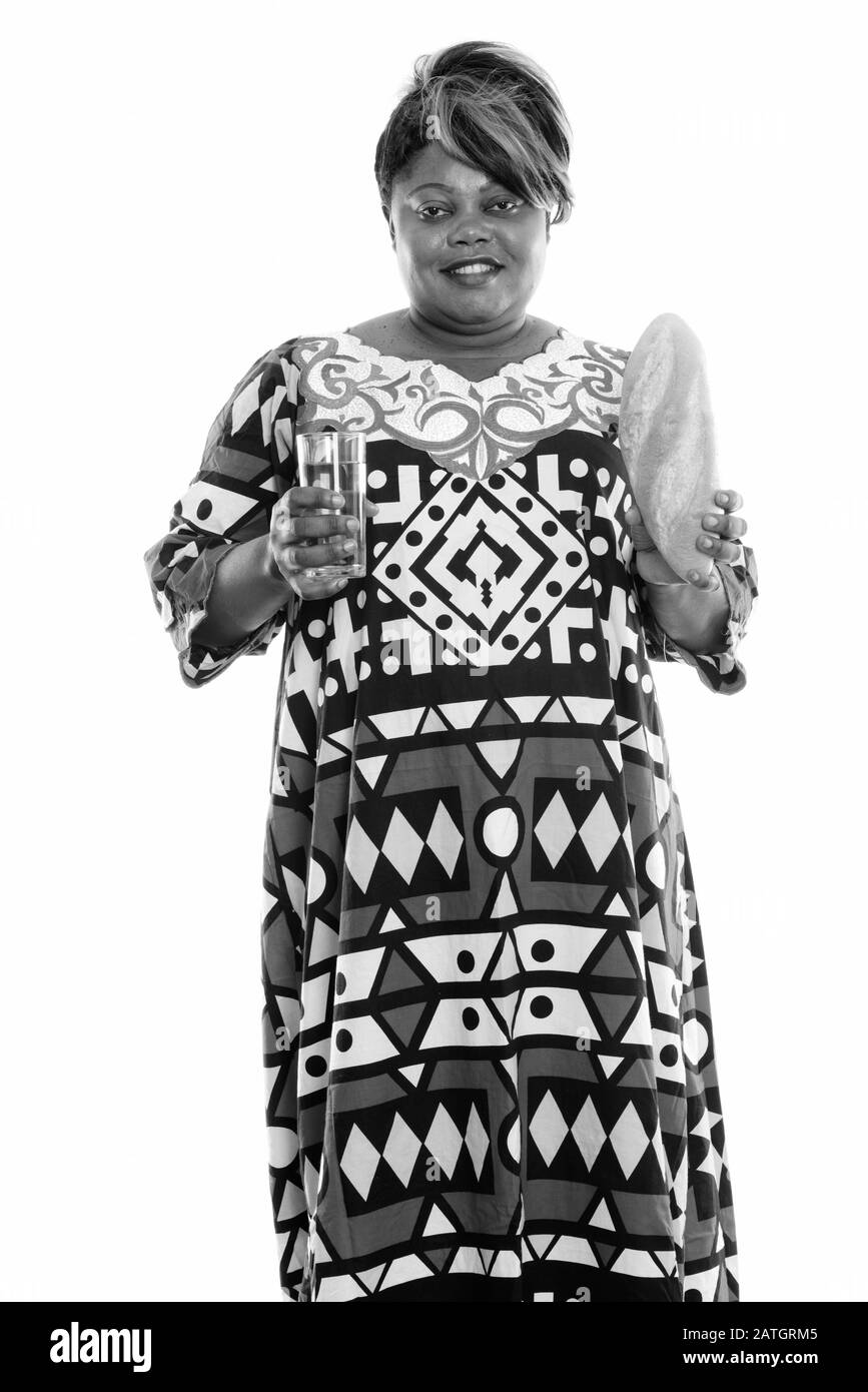 Heureuse femme noire africaine souriante et debout tout en tenant un verre de bière et de pain Banque D'Images