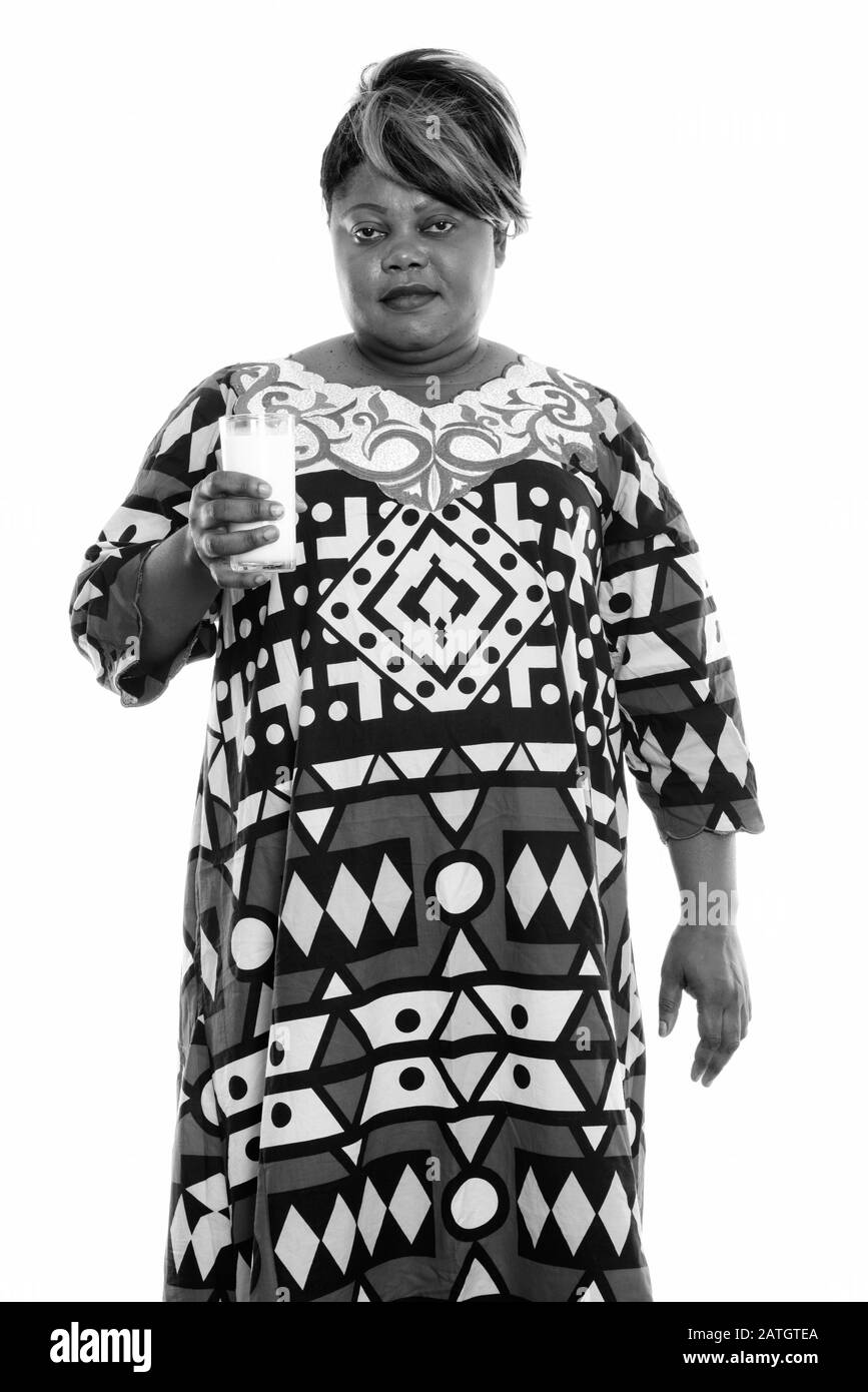 Studio tourné de graisse noire africaine femme debout tout en tenant un verre de lait Banque D'Images