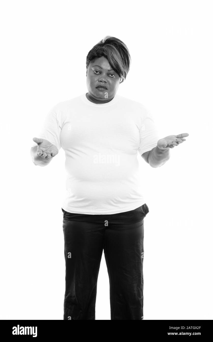 Studio tourné de grosse femme africaine noire debout tout en regardant confus prêt pour la salle de gym Banque D'Images