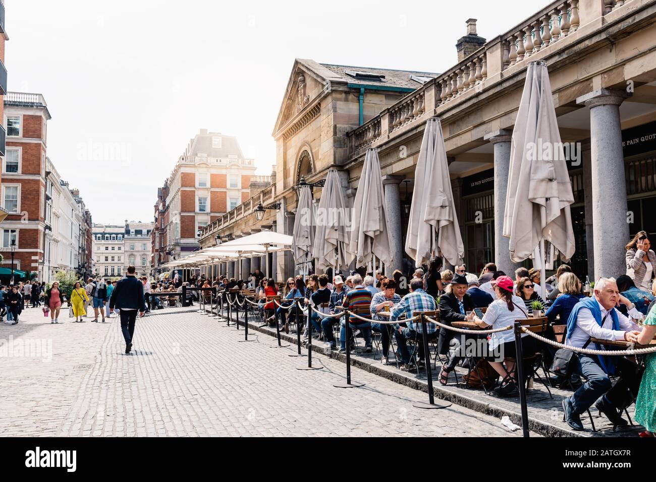 Londres, Royaume-Uni - 15 mai 2019 : vue sur le marché Covent Garden avec les terrasses de restaurant et les personnes assises. Sunflare en arrière-plan Banque D'Images