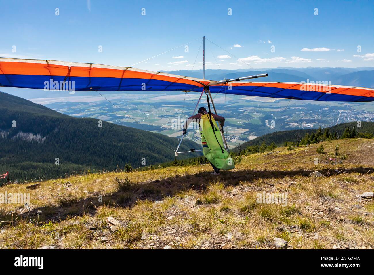 Suspendre le pilote de patin en marche et le retirer. Vue panoramique sur les montagnes de la vallée de Kootenay. Vue de derrière jusqu'au planeur de vol Hang Banque D'Images