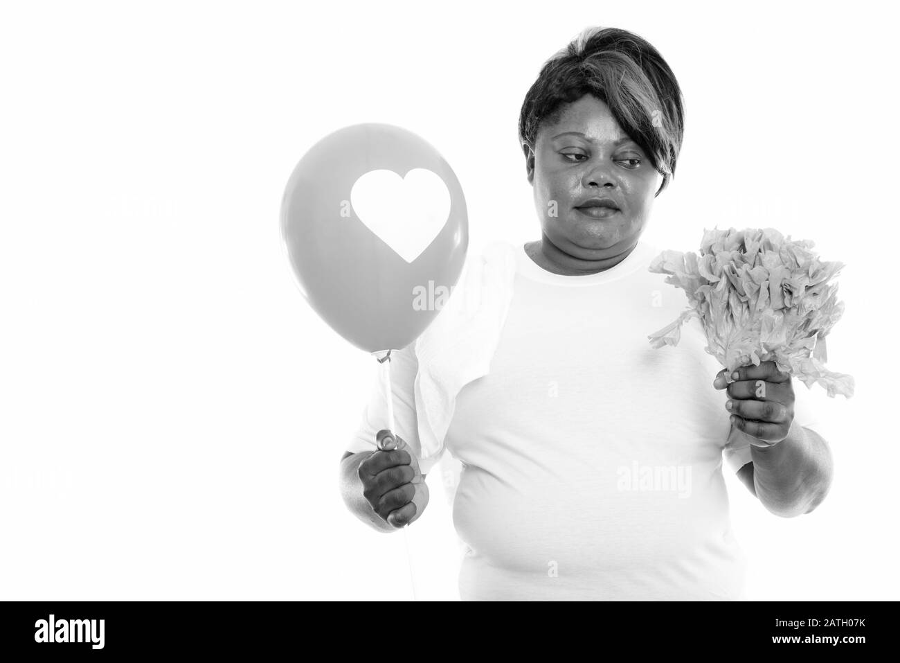 Studio tourné d'une femme africaine en surpoids tenant la laitue et le ballon prêt pour la salle de gym Banque D'Images
